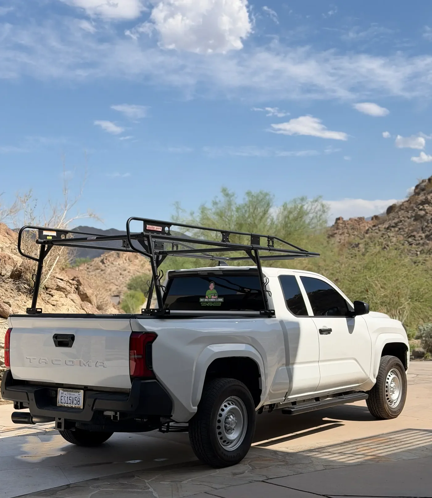 Busy Bugs Window Cleaning service truck with equipment rack at a rocky Palm Desert hillside home